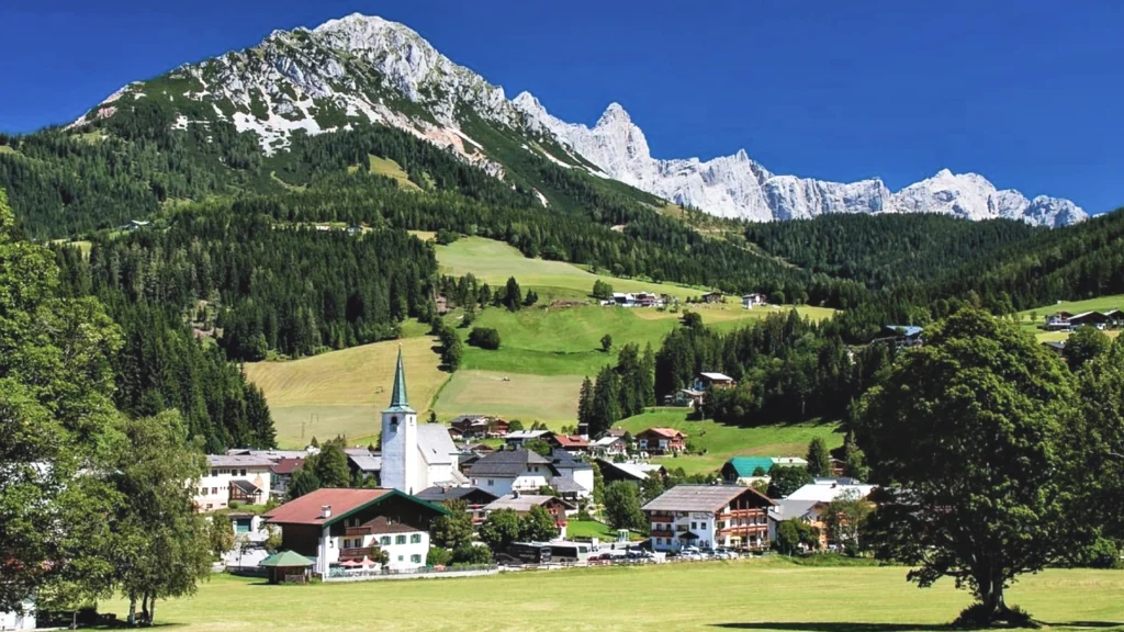 Summer in Filzmoos: Discover the lush green meadows at the foothills of the Alps, the peaceful village atmosphere, and the natural beauties meeting the deep blue sky.