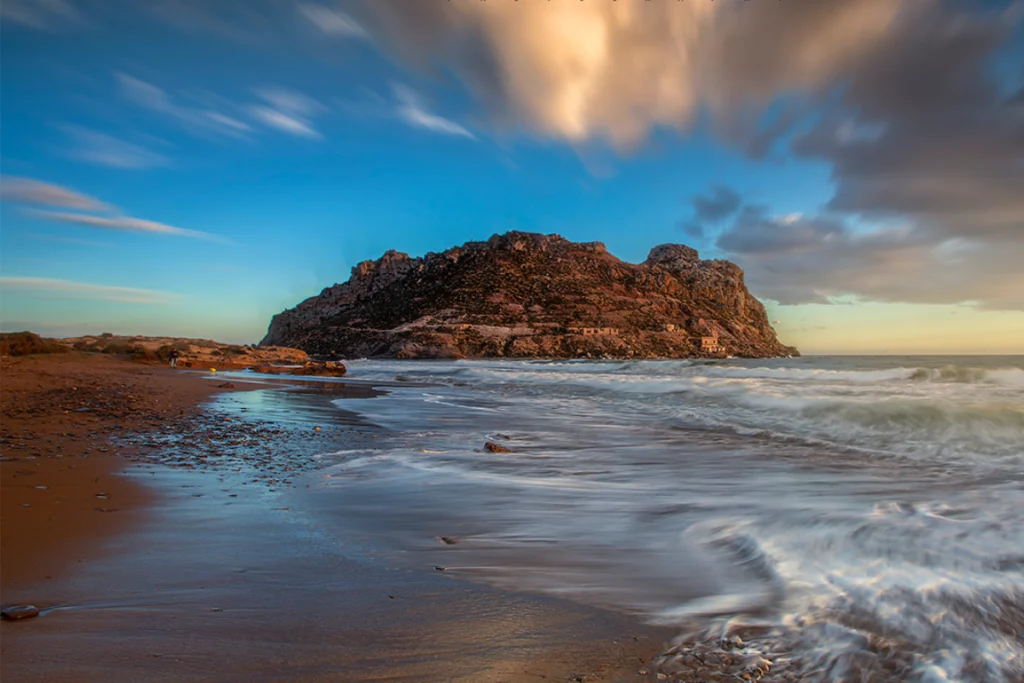 Die bezaubernde Küste von Isla del Fraile: Ein unvergesslicher Sonnenuntergang mit goldenem Sand und dem tiefblauen Wasser des Mittelmeers.