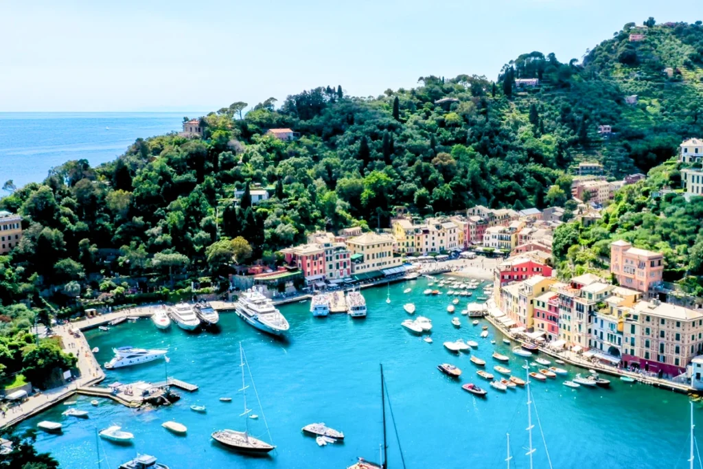 Portofino, das bezaubernde Städtchen in Ligurien, berühmt für seine farbenfrohen Häuser und seinen ruhigen Hafen. Luxusyachten, üppig grüne Hügel und das tiefblaue Wasser des Mittelmeers verleihen ihm das Aussehen einer Postkarte.