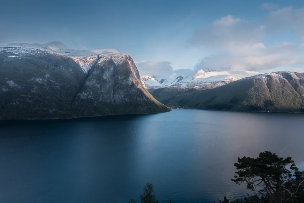 Valldal, Noruega: Uma paisagem encantadora onde os braços tranquilos dos fiordes encontram montanhas cobertas de neve e águas cristalinas.